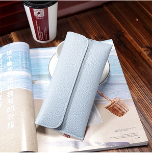 Detailed view of light blue lychee pattern long leather wallet on a wooden table