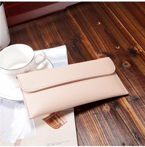 Detail of light pink pebble grain long wallet with envelope flap and precise stitching