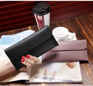 Detail view of lychee pattern leather long envelope wallets in black and soft pink colors