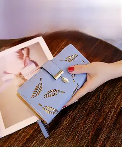 Portefeuille long bleu clair avec motif feuille ajouré et doublure dorée en main