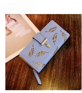 Détail d'un portefeuille long bleu clair pour femme avec motif feuille dorée évidée