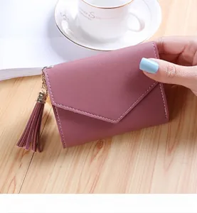 Detail of lychee pattern pink wallet featuring tassel pendant and white contrast stitching