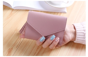 Detailed view of women's tri-fold wallet with litchi grain and tassel pendant decoration