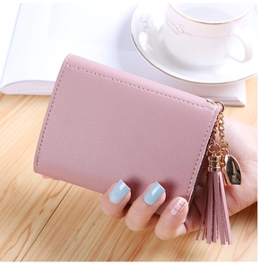Close-up of pink litchi grain small wallet with tassel and golden heart pendant