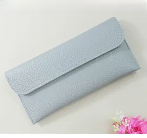 Detailed close-up of light blue pebbled leather long wallet with neat stitching details