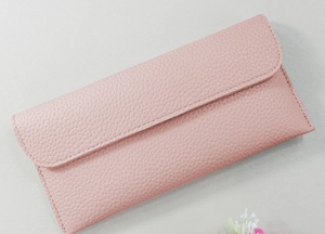 Detail of pink long wallet showing pebbled leather texture and neat stitching accents