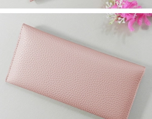 Detail of pink long wallet showing pebbled leather texture and reinforced stitching
