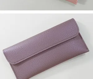 Detail shot of purple long wallet featuring lychee pattern leather and flap closure