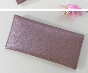 Detailed top view of a long purple wallet with litchi grain texture and a metal snap button
