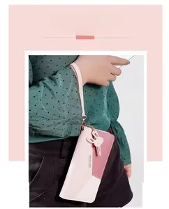 Detail of pink patchwork faux leather clutch bag with tassel and zip closure