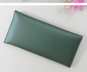 Detailed view of the dark green pebbled texture on a long minimalist wallet for women