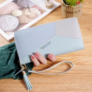 Detail of light blue and grey patchwork leather wallet with wristlet and decorative tassel