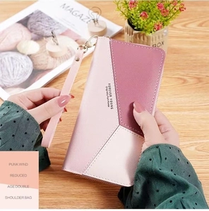 Close-up of long patchwork wallet with pink geometric panels and detachable wrist strap