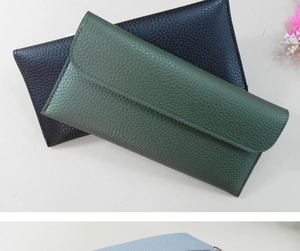 Detail of slim long envelope wallets in dark green and black with lychee grain texture