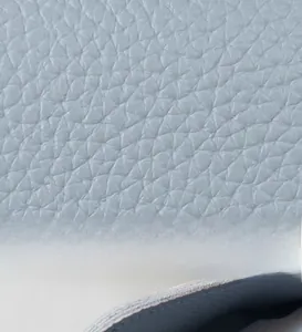 Detailed macro view of light blue lychee pattern leather texture and fine edge stitching