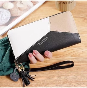 Detail of long contrast color zipper wallet with tassel and rabbit charm in hand