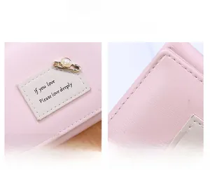 Detail of pink leather wallet featuring precise stitching and decorative pearl pin charm