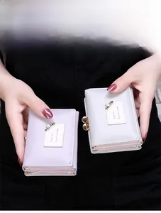 Detail of short tri-fold wallet for women with pearl pin and vintage metal clasp