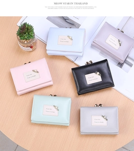 Short tri-fold wallets for women in six pastel colors on a rustic wooden table background
