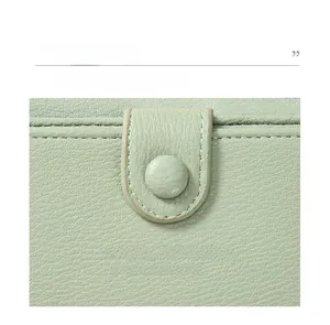 Detailed macro view of mint green pebble grain leather texture with neat stitching