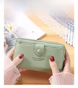 Detail of light green PU leather wallet with litchi texture and secure wrist strap