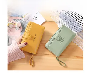 Detail view of yellow and mint green long wallets featuring lychee texture and wristlets