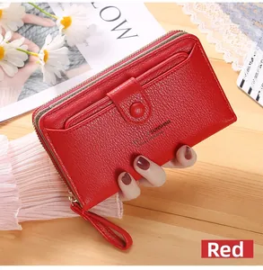 Close-up of red lychee grain leather wallet with wristlet and Infinite Sunshine text