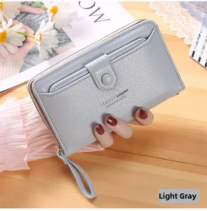 Detail of light purple pebbled leather wallet with wristlet on a wooden background