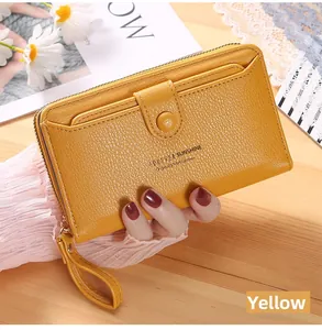 Macro shot of long yellow faux leather wristlet wallet with metal zipper and magnetic flap