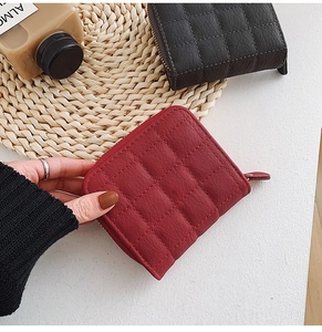 Close-up of quilted leather mini wallets with zipper closure and textured pattern