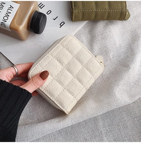 Close-up of mini quilted leather coin purse with gold zipper and textured finish