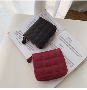Close-up of diamond quilted leather mini wallets in black and burgundy with zip closure