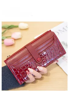 Detail of burgundy stone texture long wallet with gold zipper and stylish clasp
