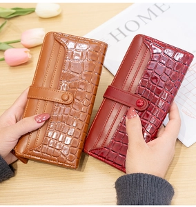 Detail of stone pattern long wallets in caramel brown and wine red with buckle closure