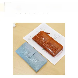 Detail of light blue and brown crocodile pattern wallets on wooden surface