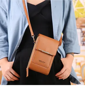 Détail de la pochette téléphone en cuir marron avec zips multicouches et bandoulière fine