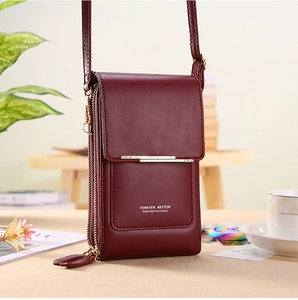 Détail du sac de téléphone bordeaux avec garniture dorée et compartiments zippés pratiques