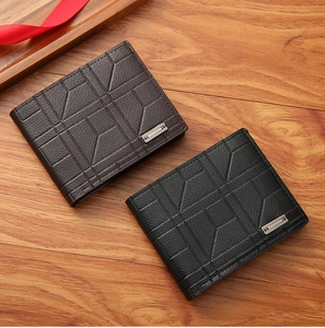 Detail of short leather wallets for men with geometric pattern and metal logo on wood