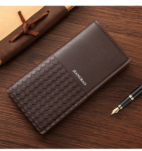 Detail view of brown men's long wallet featuring woven texture on dark wood background