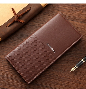 Detail of a brown woven leather long wallet with zipper and elegant branding on wood