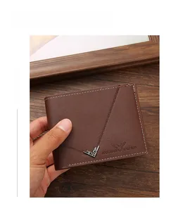 Detail of brown leather men's wallet with white stitching and metal corners