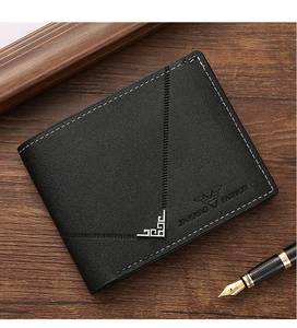Close-up of black leather wallet with white stitching and silver corner detail on wood