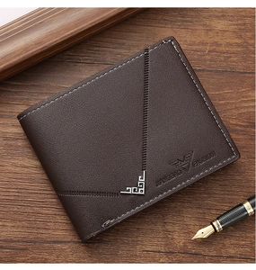 Detail of dark brown leather bifold wallet with eagle logo and silver corner on wood