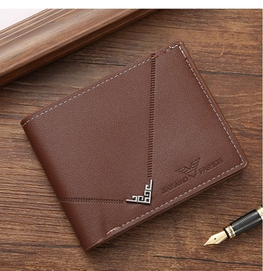 Detailed close-up of a brown leather wallet with eagle embossing and metallic corner