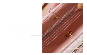 Gros plan du bouton pression magnétique et du cuir rose grainé du petit portefeuille