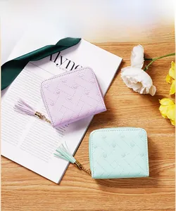 Détail de portefeuilles carrés lilas et menthe avec gaufrage cœur et pompon décoratif