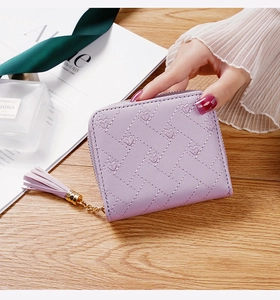 Détail du portefeuille lavande brodé de cœurs avec pompon en cuir et zip doré élégant