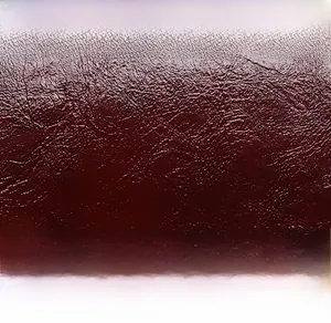 Vista macro della trama della pelle litchi bordeaux sul portafoglio minimalista da donna