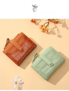 Detail view of crocodile pattern wallets in caramel and mint green with card slots
