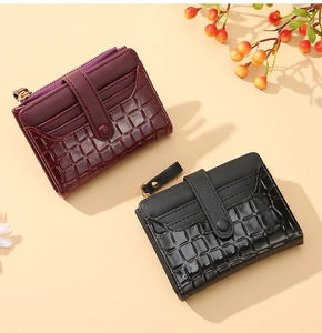 Detailed view of crocodile pattern card wallets in wine red and black leather